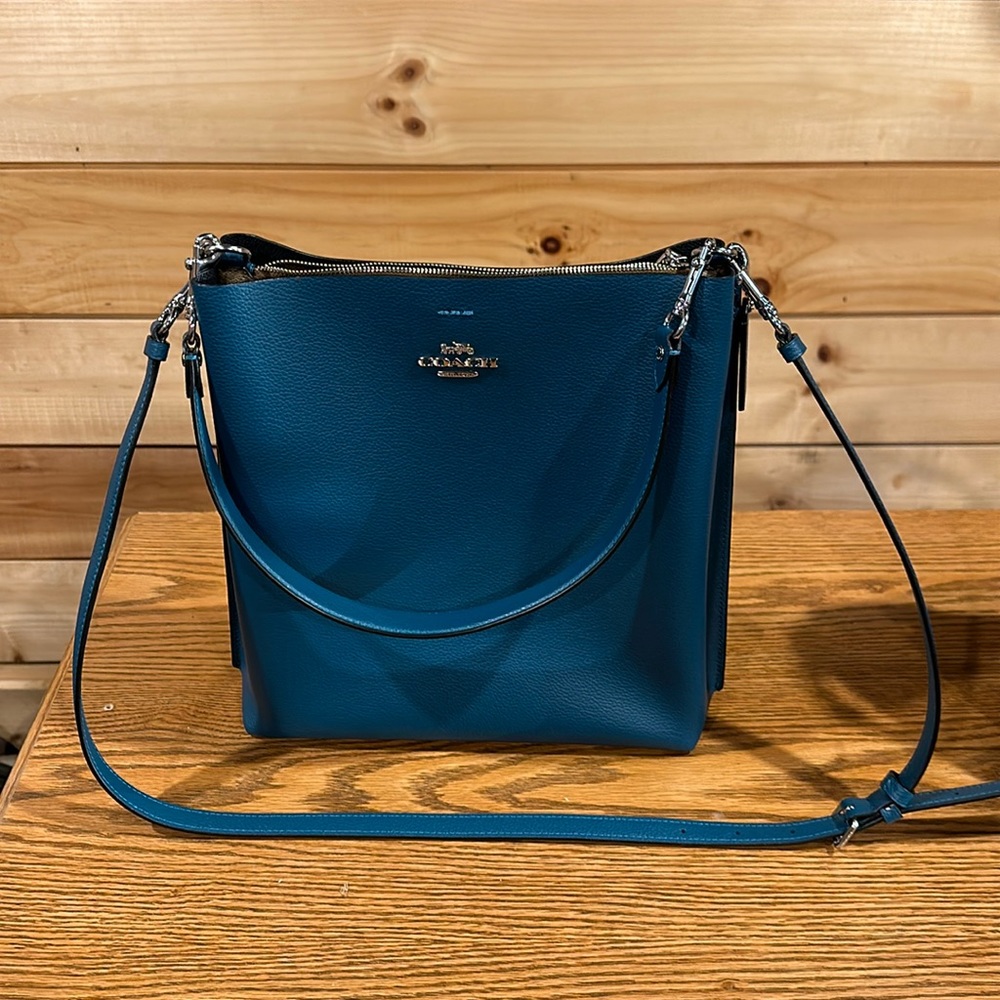 Teal Coach bag with hand and should straps.